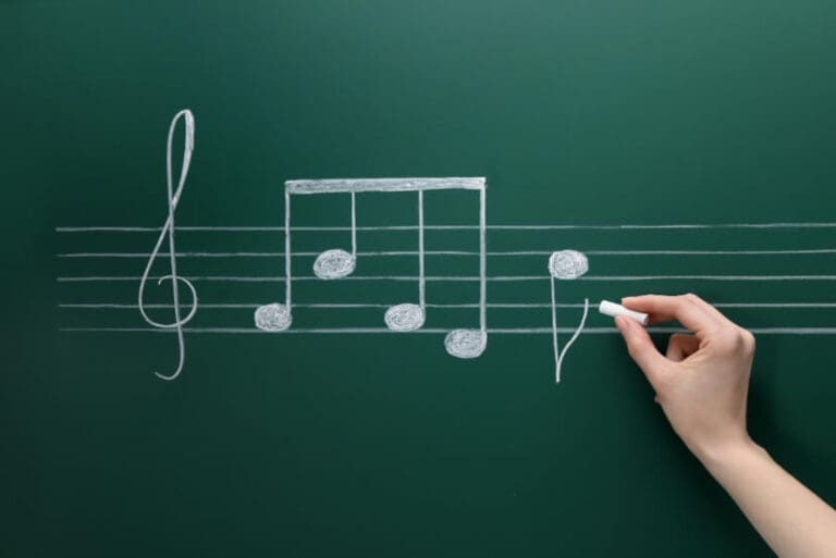 woman writing musical notes with chalk blackboard closeup